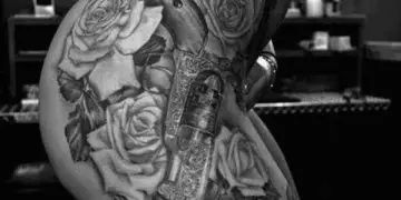 Guns and roses thigh tattoo